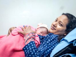 नेपालमा नवजात शिशुलाई काखमा राखेकी आमा