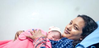 नेपालमा नवजात शिशुलाई काखमा राखेकी आमा