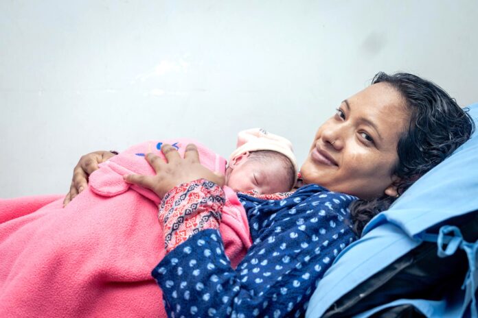 नेपालमा आमा र नवजात शिशु नेपालमा नवजात शिशुलाई काखमा राखेकी आमा
