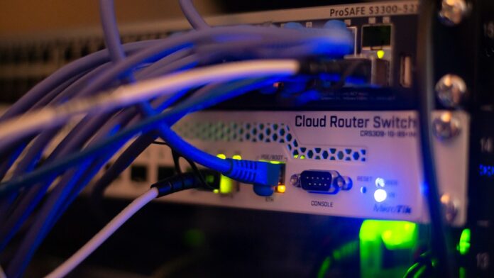 Network equipment and cybersecurity Network cables connected to computer networking equipment, illustrating digital infrastructure and cybersecurity