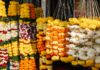 Orange marigold garlands hanging at a roadside flower shop; representative image for Nepal's Tihar flower market, not a photograph of the specific affected farms.