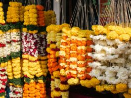 Orange marigold garlands hanging at a roadside flower shop; representative image for Nepal's Tihar flower market, not a photograph of the specific affected farms.