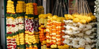 Orange marigold garlands hanging at a roadside flower shop; representative image for Nepal's Tihar flower market, not a photograph of the specific affected farms.