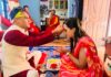 Family celebrating Vijaya Dashami by applying tika and jamara