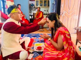 Family celebrating Vijaya Dashami by applying tika and jamara
