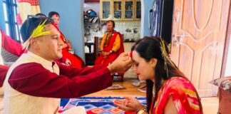 Family celebrating Vijaya Dashami by applying tika and jamara