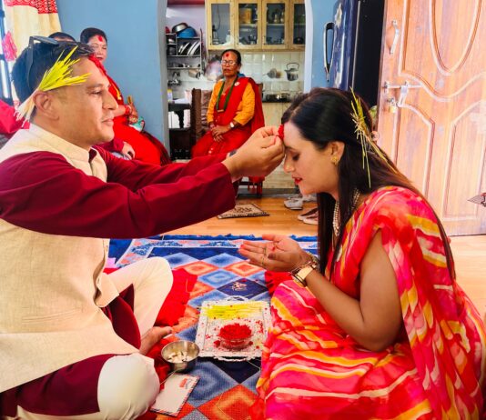 Family celebrating Vijaya Dashami by applying tika and jamara