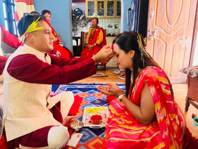 Family celebrating Vijaya Dashami by applying tika and jamara