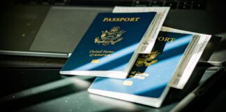 कम्प्युटर किबोर्डमाथि राखिएको राहदानीको प्रतिनिधिमूलक तस्बिर; नेपालमा ई–पासपोर्टको अनलाइन आवेदन प्रक्रियासम्बन्धी जानकारी